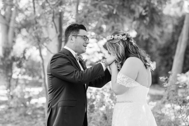 bride kisses grooms hands during emotional first look