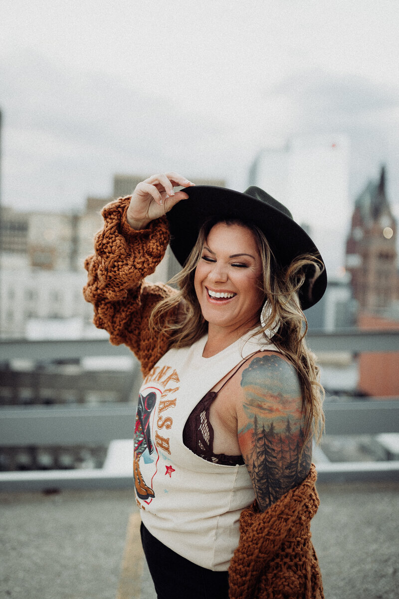 Photographer Kate Schaper wearing a boho hat with wind blowing through her hair.
