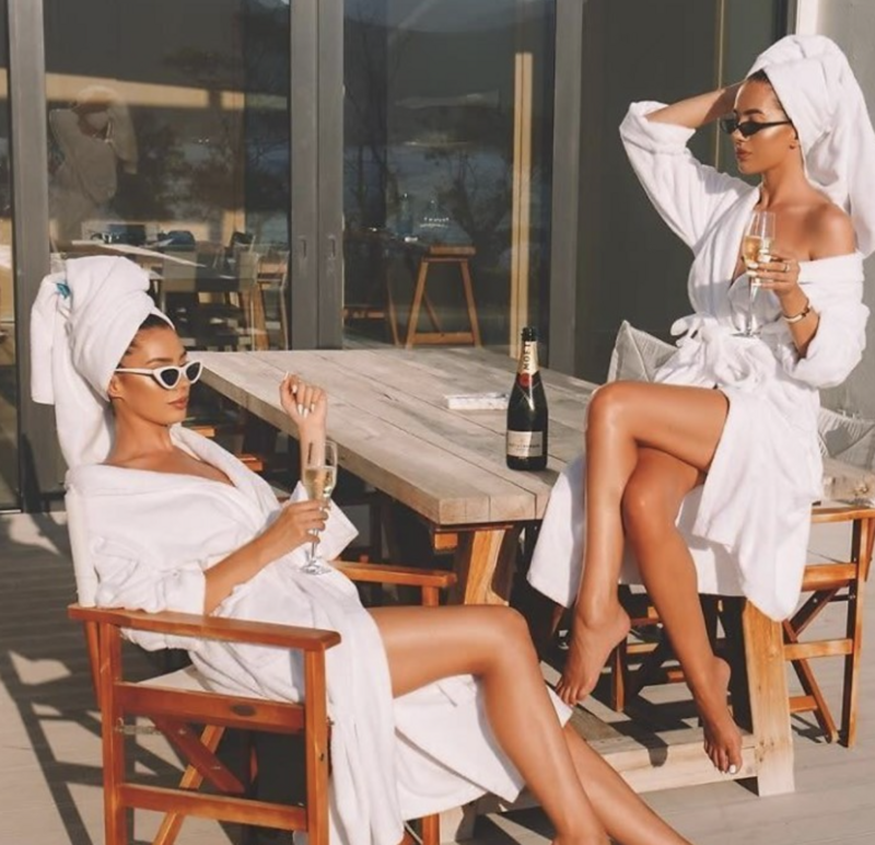 A visually appealing image evoking a spa day aesthetic, perfect for website design inspiration for salons and spas. Showcases women relaxing in robes, suggesting a luxurious and high-design website feel for businesses focused on wellness and self-care