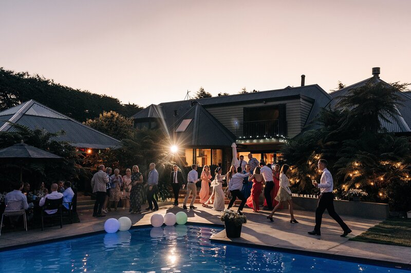 wide shot of a backyard wedding reception beside a pool in christchurch