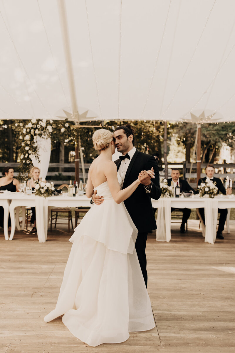 couple enjoying a quiet moment right after their elegant floral filled barn reception space reveal