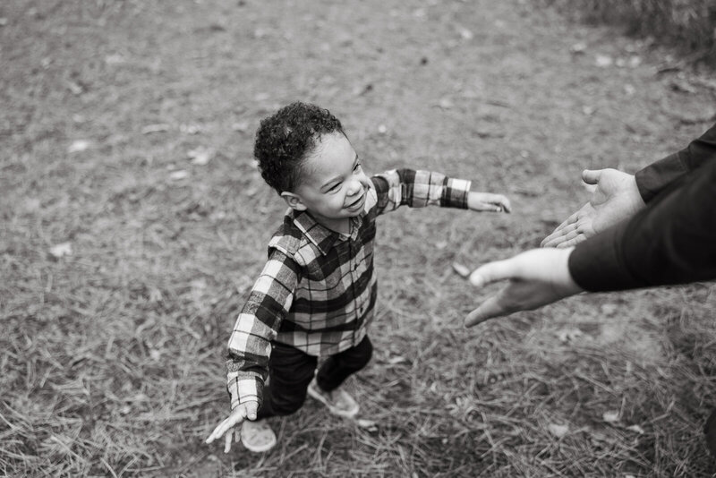 Little boy playing at the park running toward his parents. 