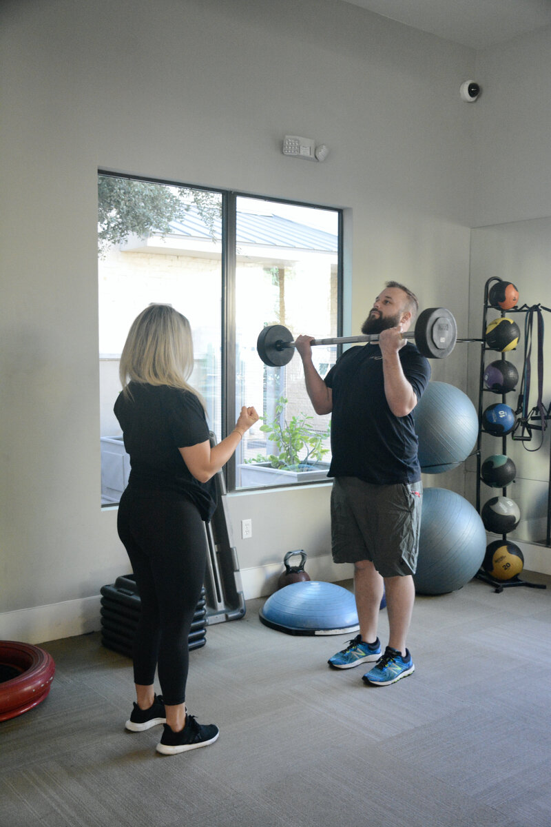 Britni coaching client lifting weights