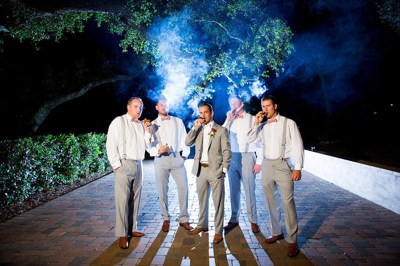 groomsmen smoking with groom night time