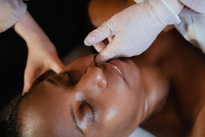 Buccal massage technique performed inside the cheek for facial sculpting.