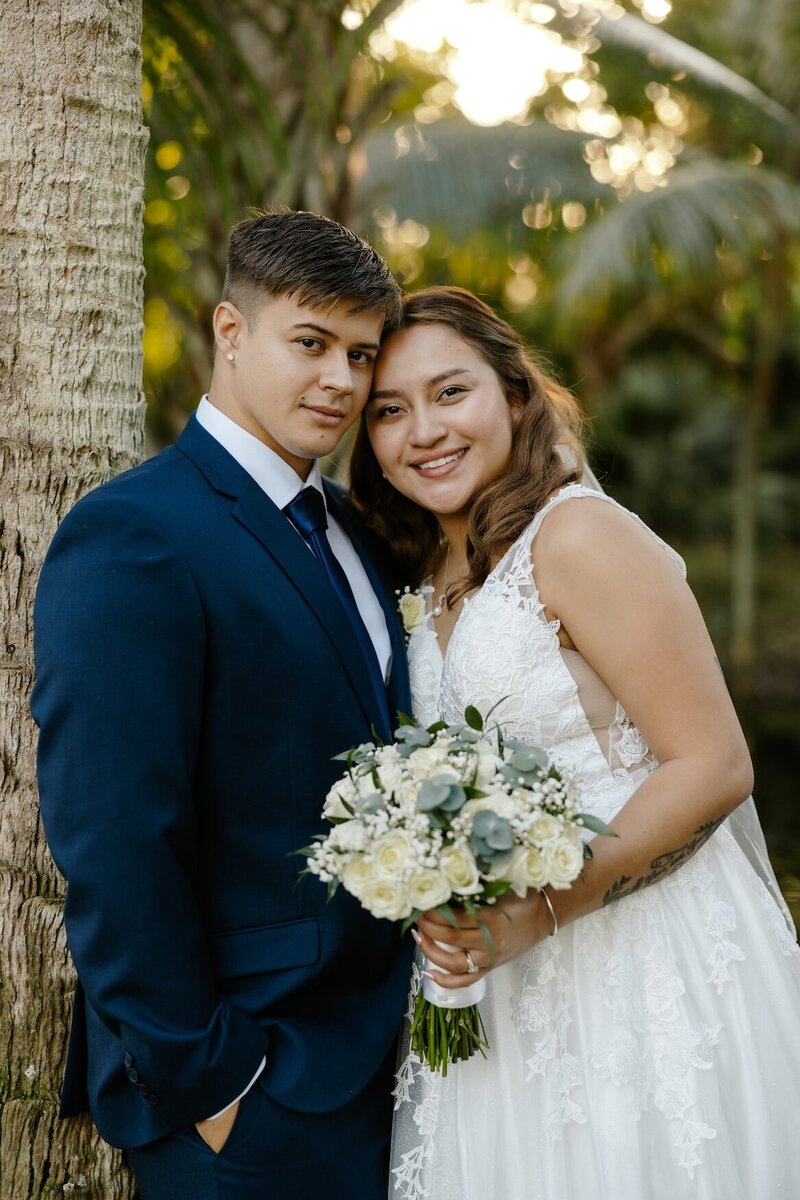 bride and groom pose for pictures after wedding in south florida