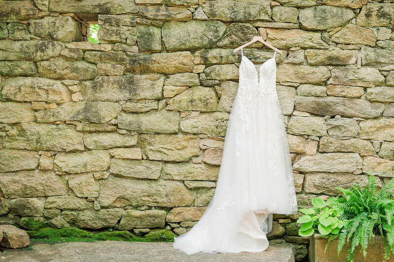 dress hanging by a stone wall