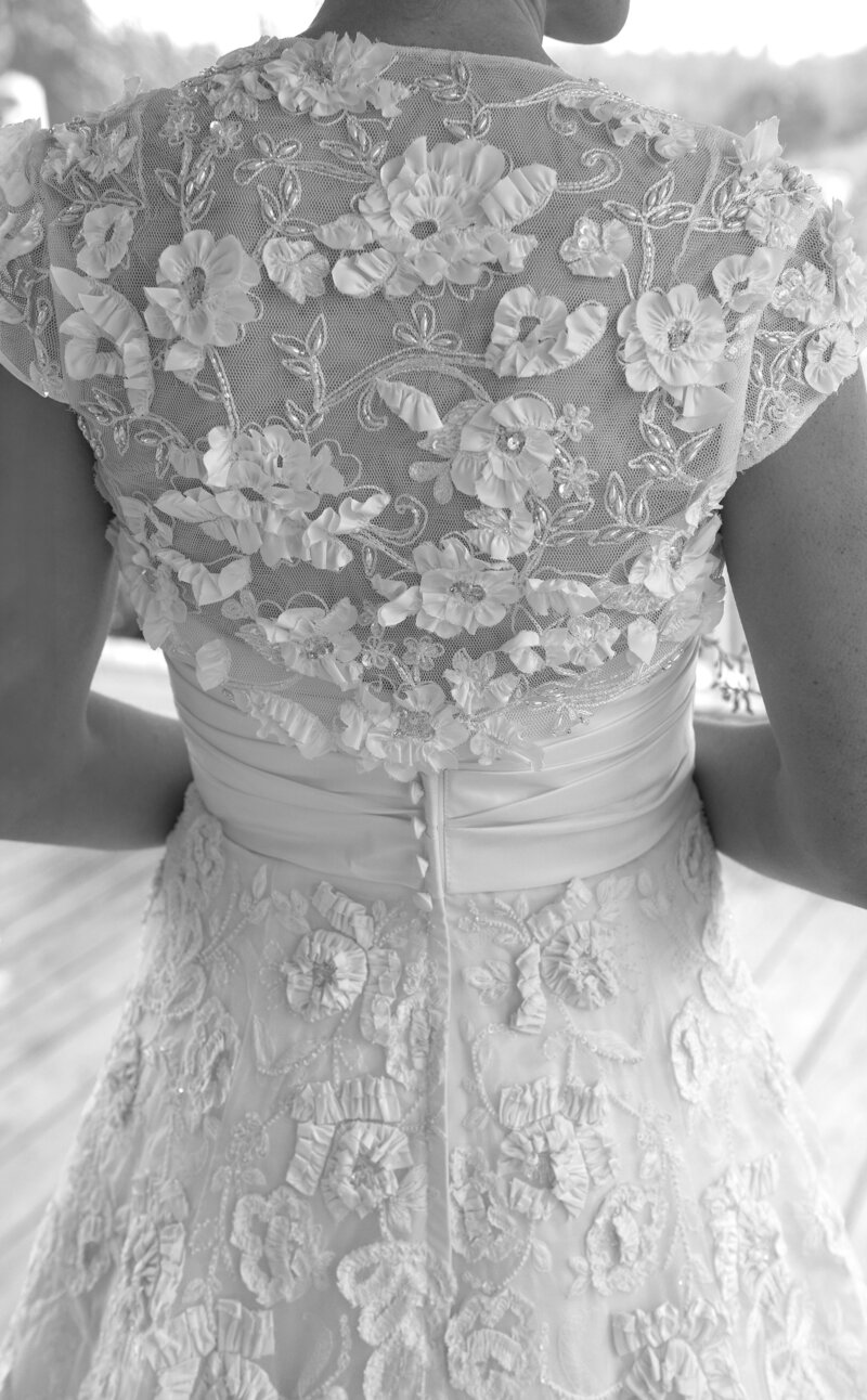 Bride shows off elaborate embroidered back of her wedding dress during her Vermont wedding day.