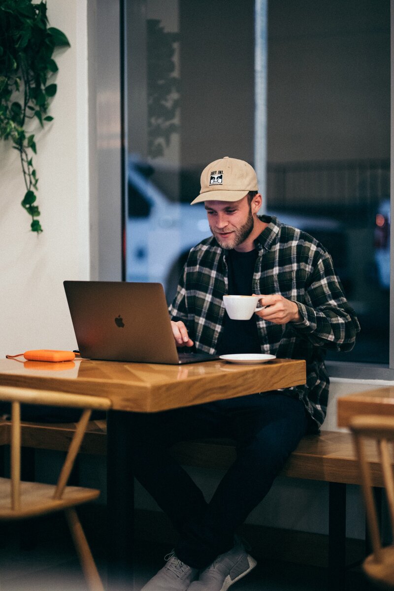 Man in suit on the phone with laptop and coffee