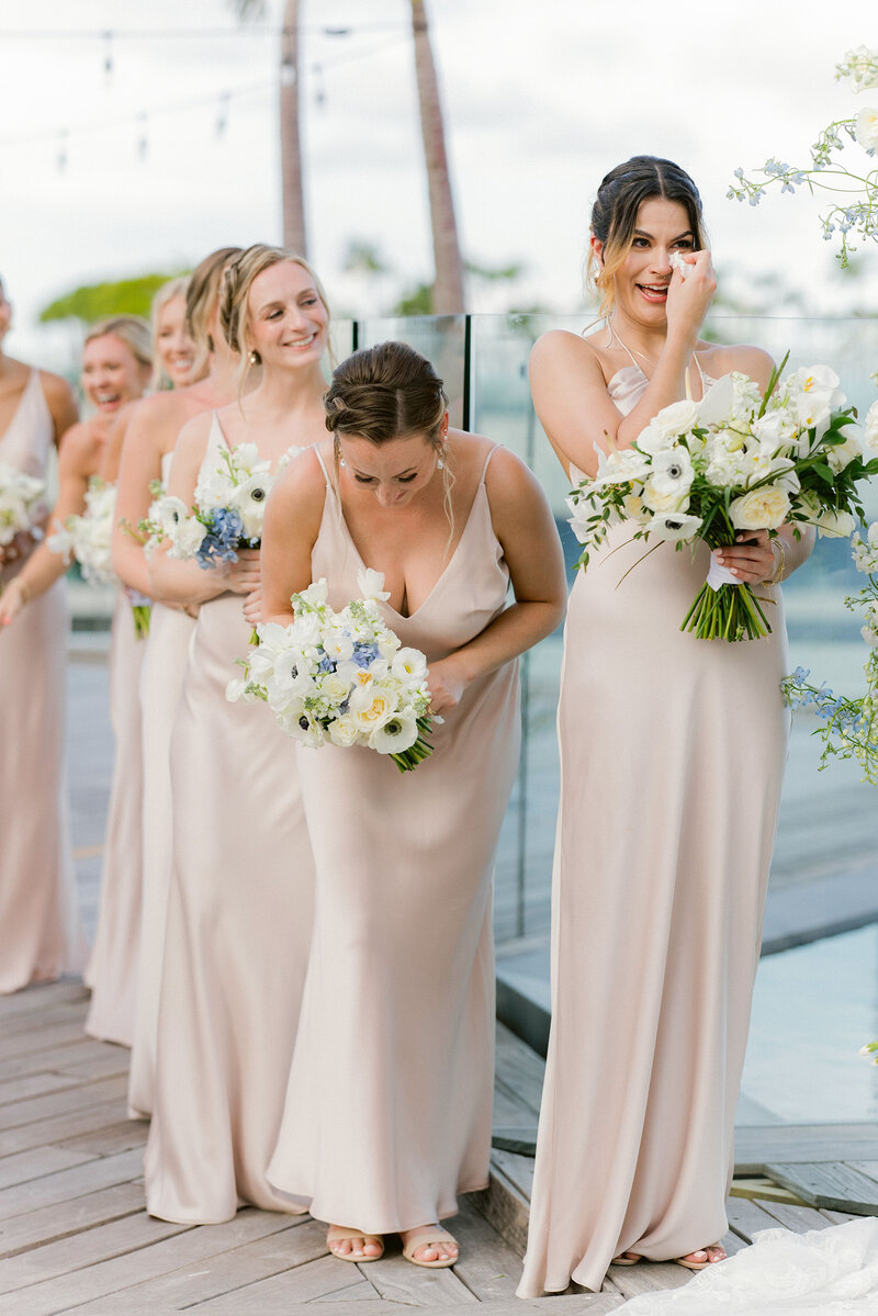 Bridesmaids in blush dresses standing with bouquets during a destination wedding celebration