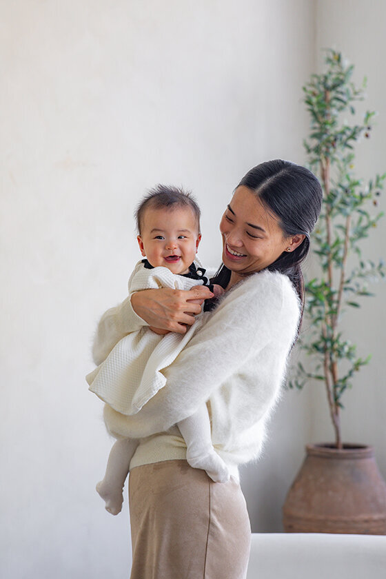 Mom smiling with her baby in DTLA studio portrait