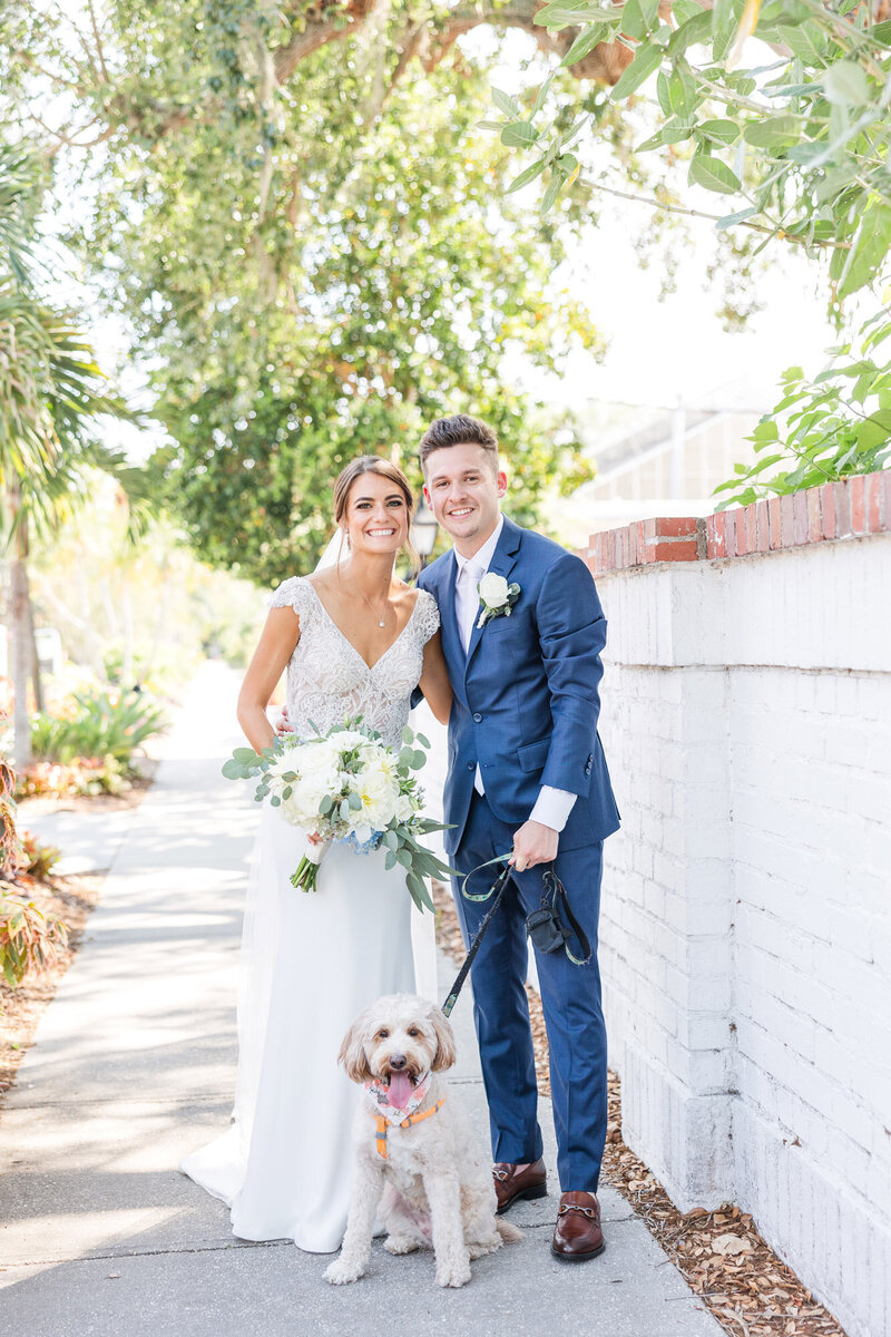 bride and groom smiling with their dog