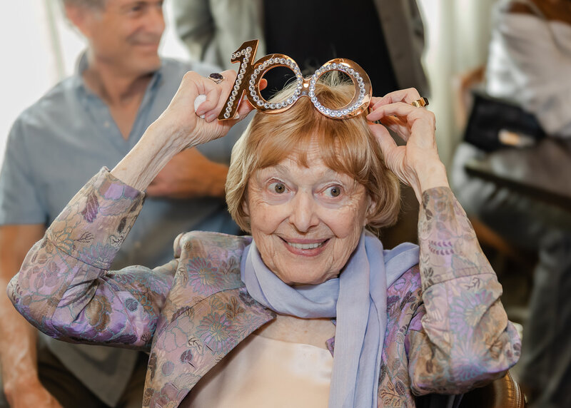 Centenarian posing with her "100" glasses at her birthday party.