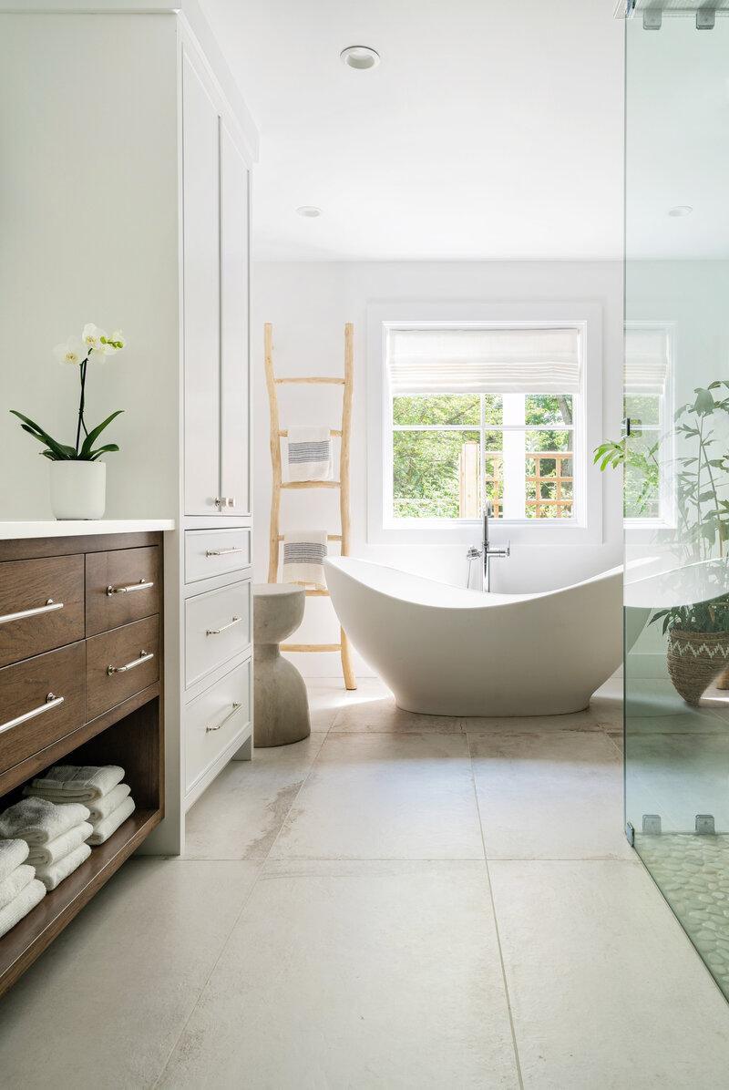 bright white bathroom with soaking tube and wood accents