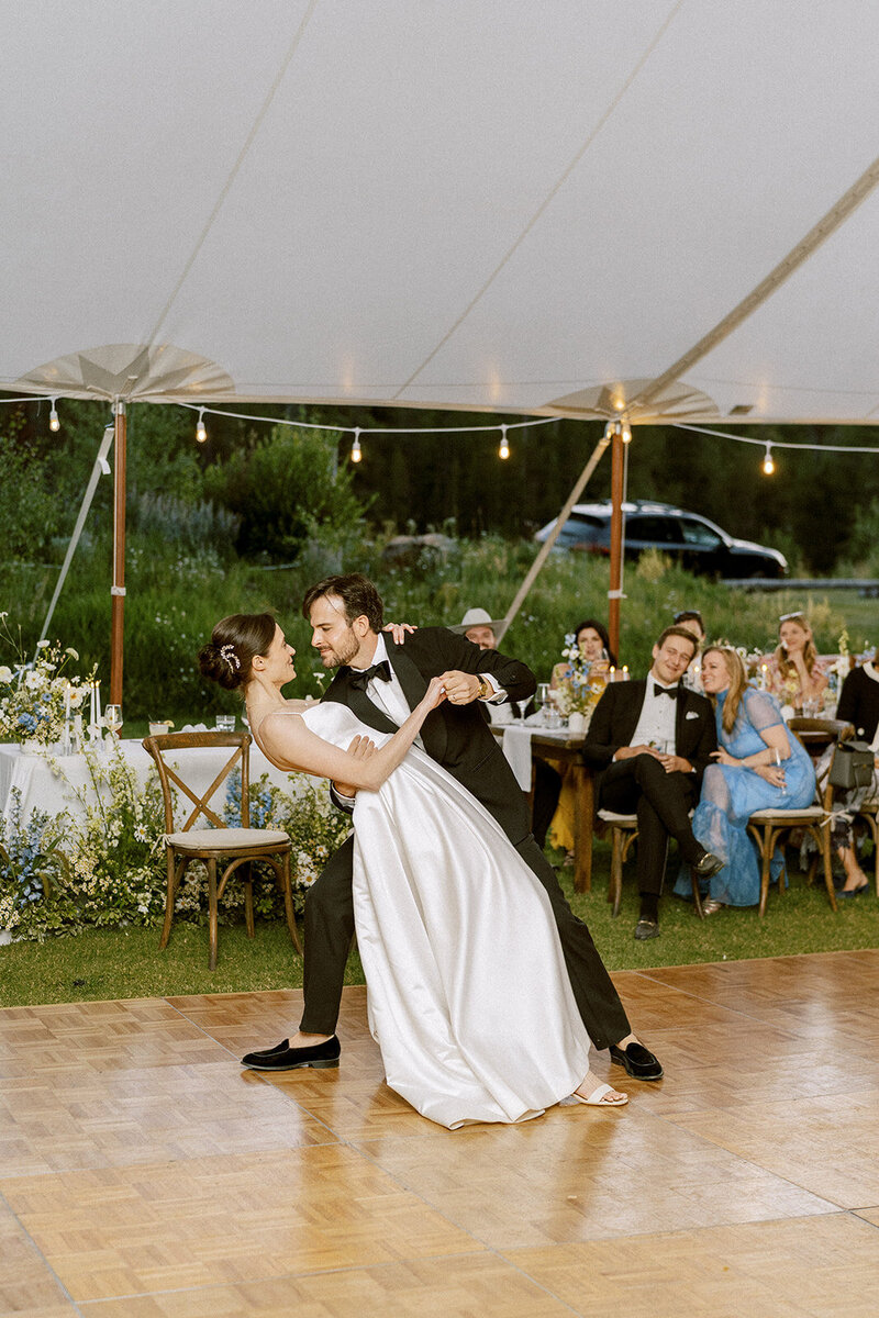 Groom in tux dipping smiling bride on dance floor at Galena Lodge wedding in Sun Valley Idaho planned by Luxe NW