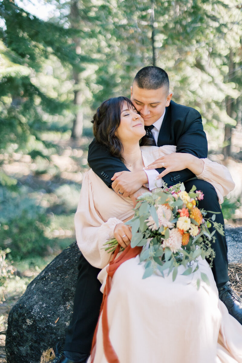 Groom embraces his bride in Lake Tahoe mountains