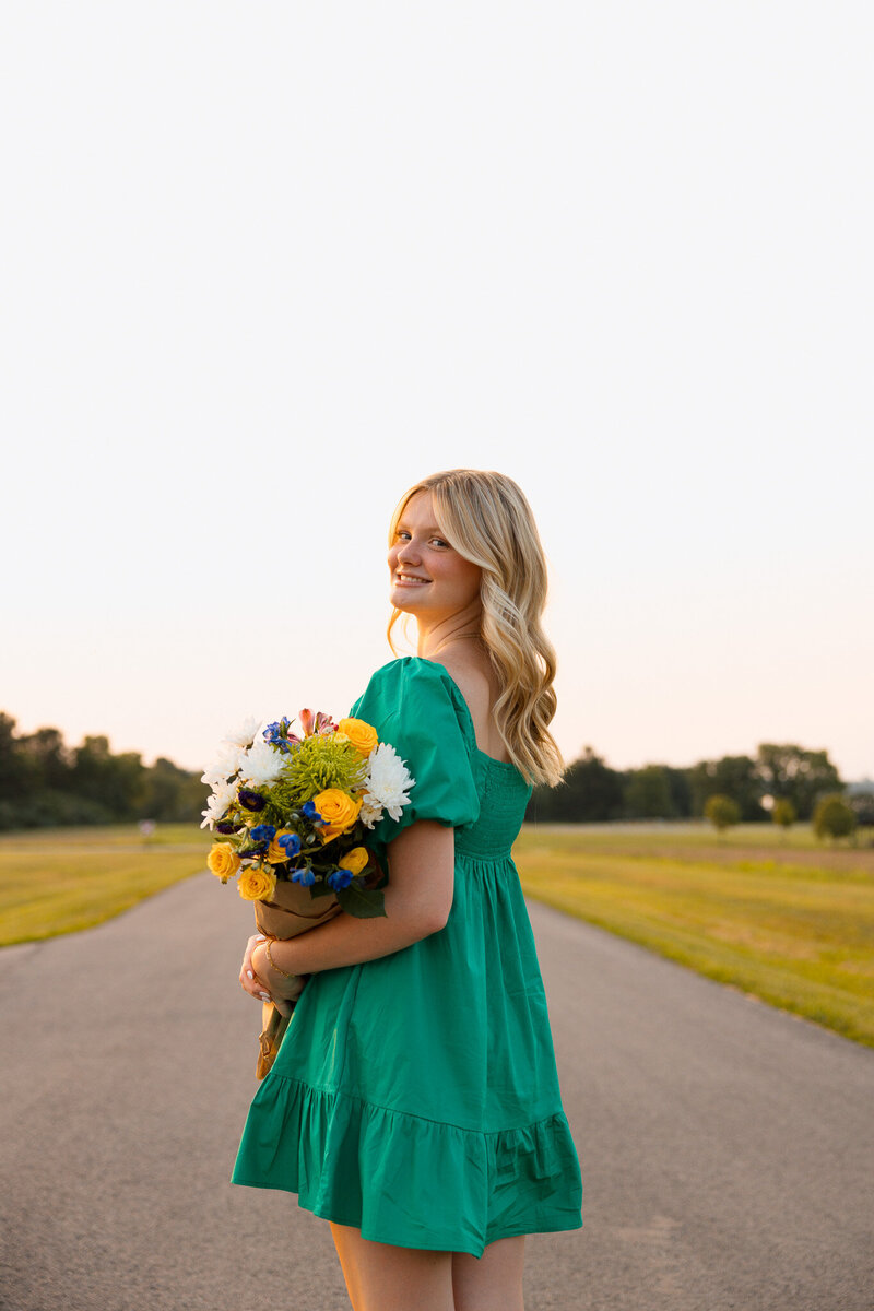 girl poses in forest for senior photos
