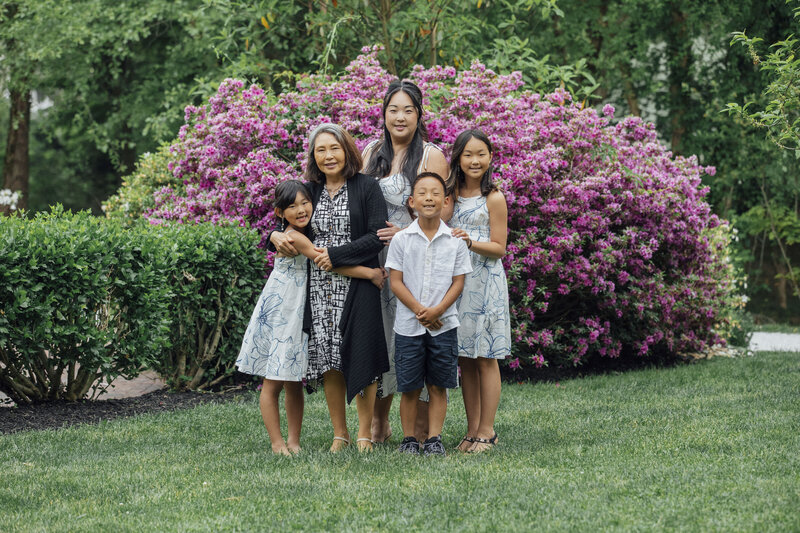 Family Portrait Photographer | Family posing together surrounded by flowers at Sayen House and Gardens | Hamilton, New Jersey