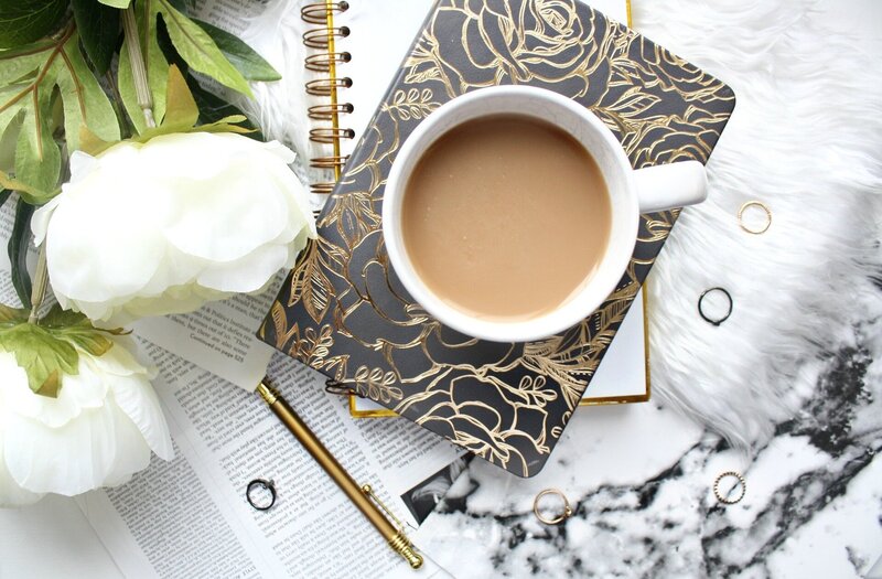 Hero image for contact page: peony flowers with coffee and notebook.