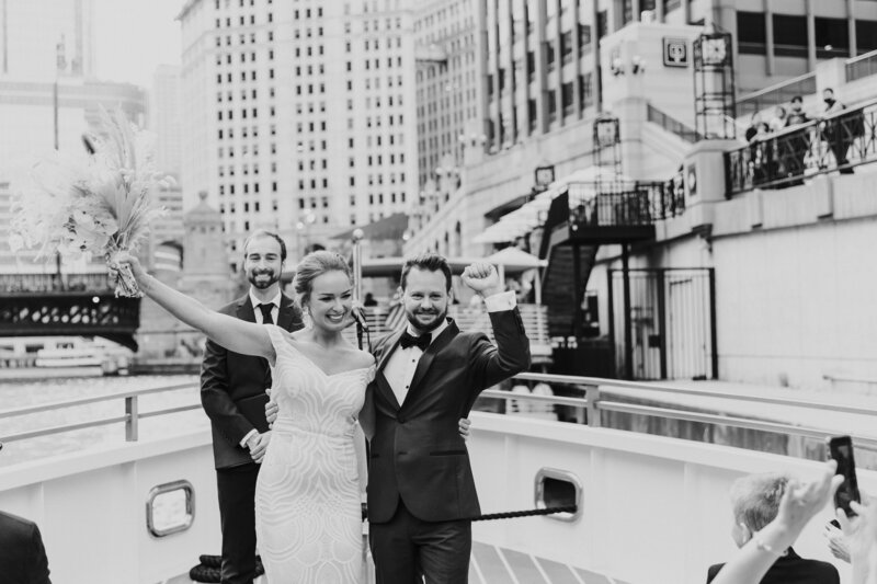 Black and white wedding photo of  outdoor bride and groom being presented by officiant