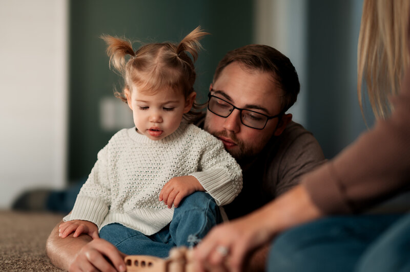 Dad and toddler playing together on the floor during a relaxed Story of Home session.