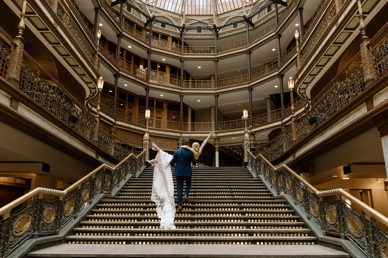 Groom carrying bride upstairs at the Cleveland Arcade. 