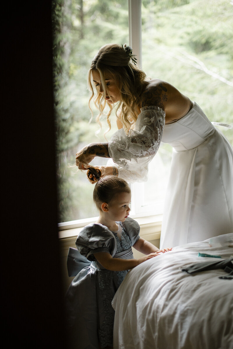 Bride doing hair for flower girl