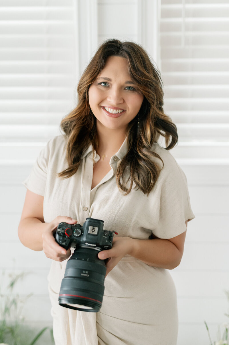 A classic and clean photo of Emily Peters holding her camera. 