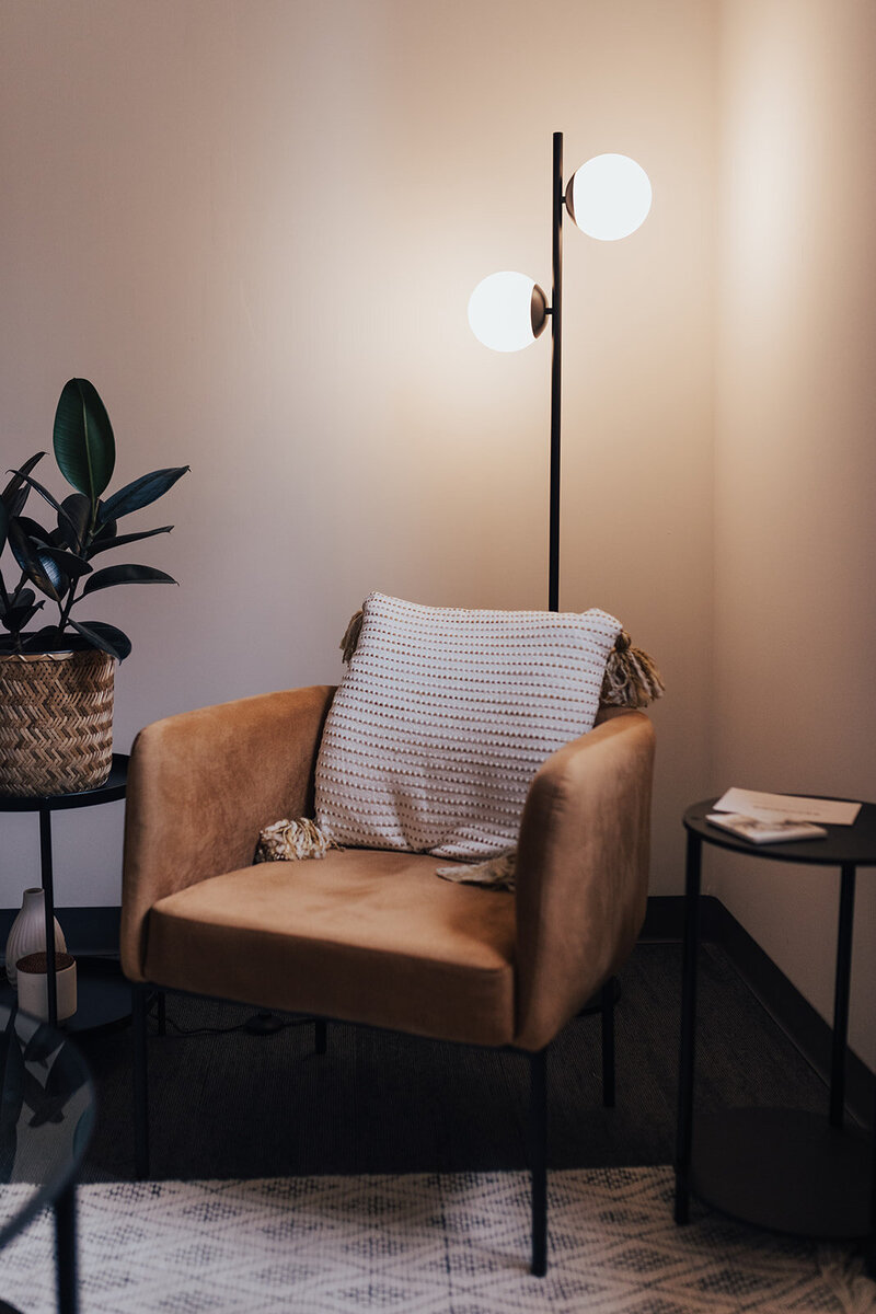 Velvet brown chair and plant inside psychology office.