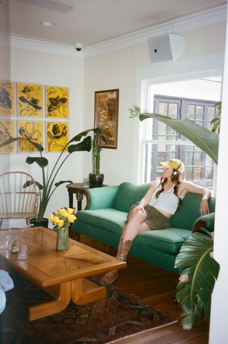 women sitting on a couch wearing headphones and cowgirl boots