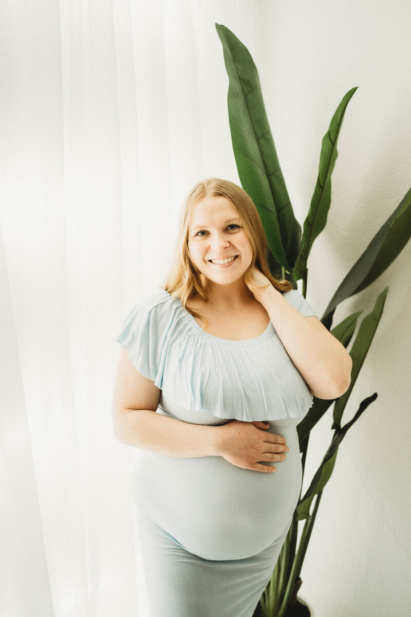 Pregnant mom in black Calvin Klein sports bra  for a studio maternity session.