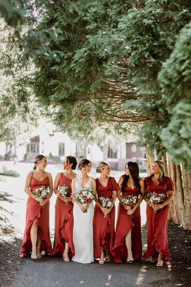 bride and bridesmaids smiling at each other