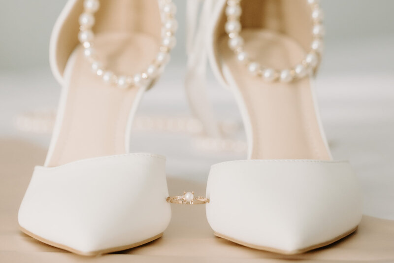 ring between two bridal shoes