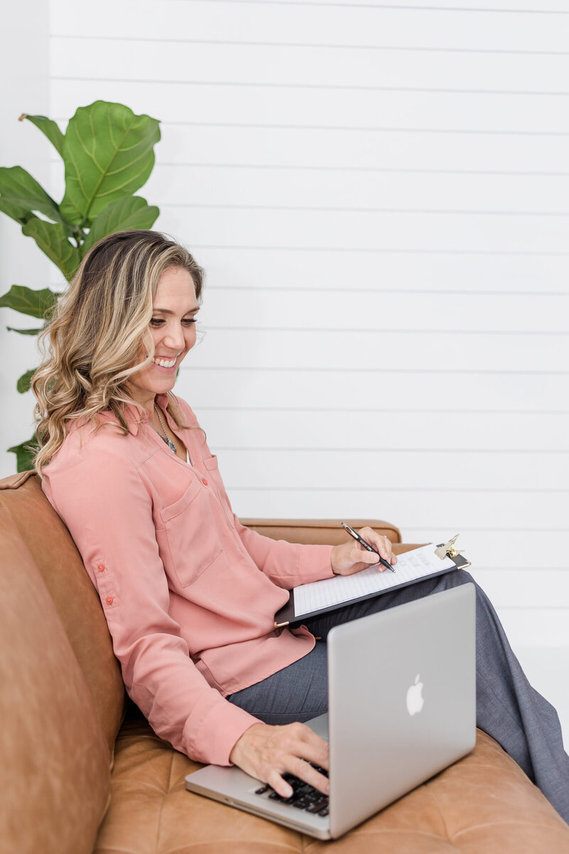 Woman sitting writing on a note pad
