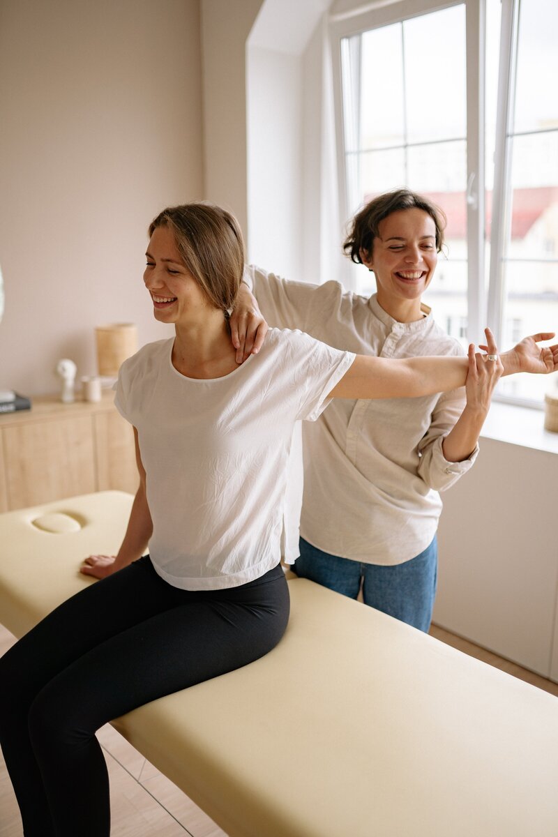 Physical Therapist working on patient's lower neck and shoulder.