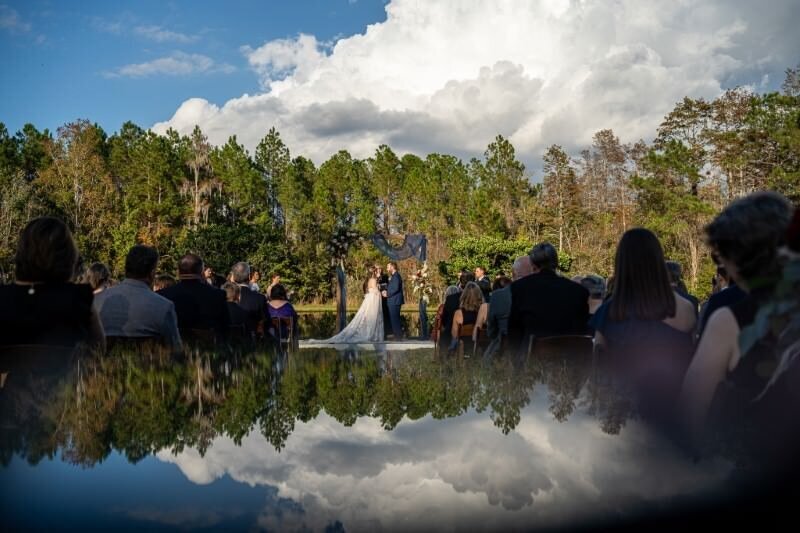 wedding ceremony with guests watching blue sky and reflection