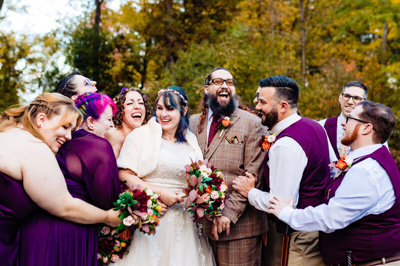 a laughing bride and groom surrounded by the wedding party at Toledo Country Club