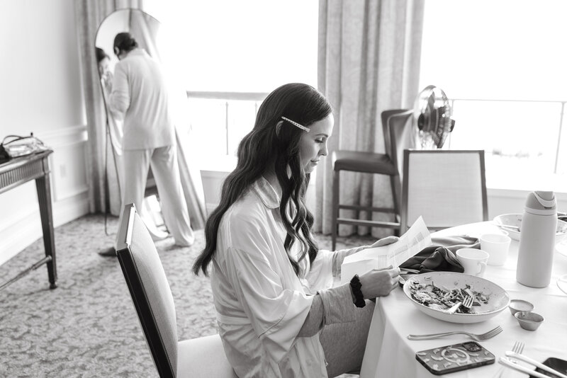 View of the brides lace button up gown and veil, as she looks at herself in the mirror 