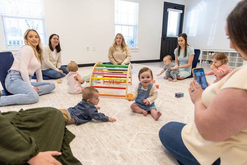 Group of women sitting in a circle on the floor with their babies