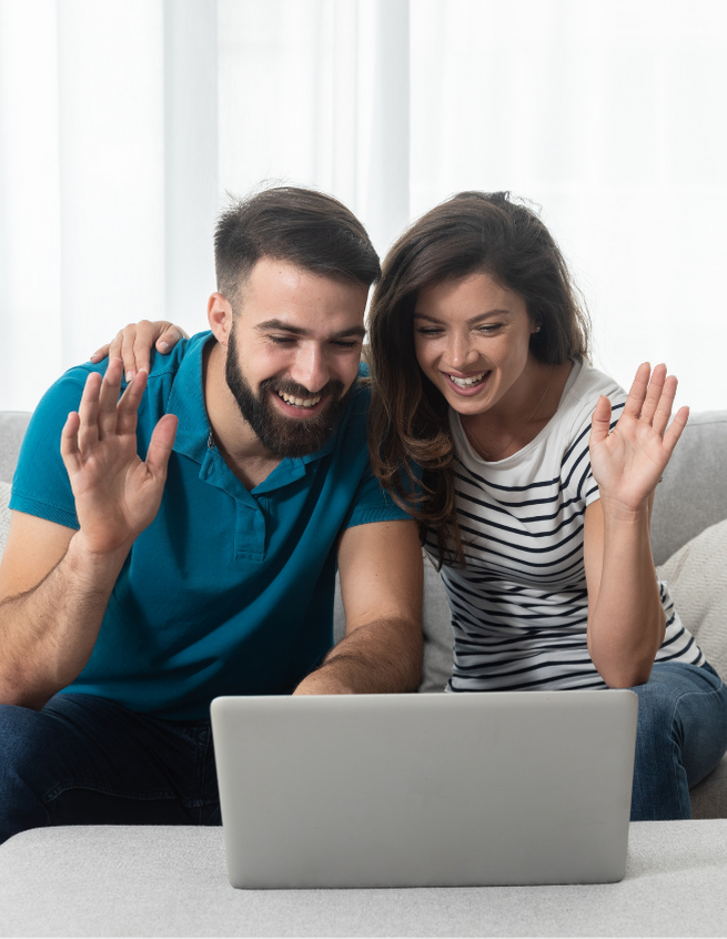 A smiling couple wave together at their laptop screen. This could represent what an online couples counseling session in Florida might look like. Idit Sharoni offers couples therapy in Florida, marriage counseling, and other services. Contact a couples therapist in Florida for support today!