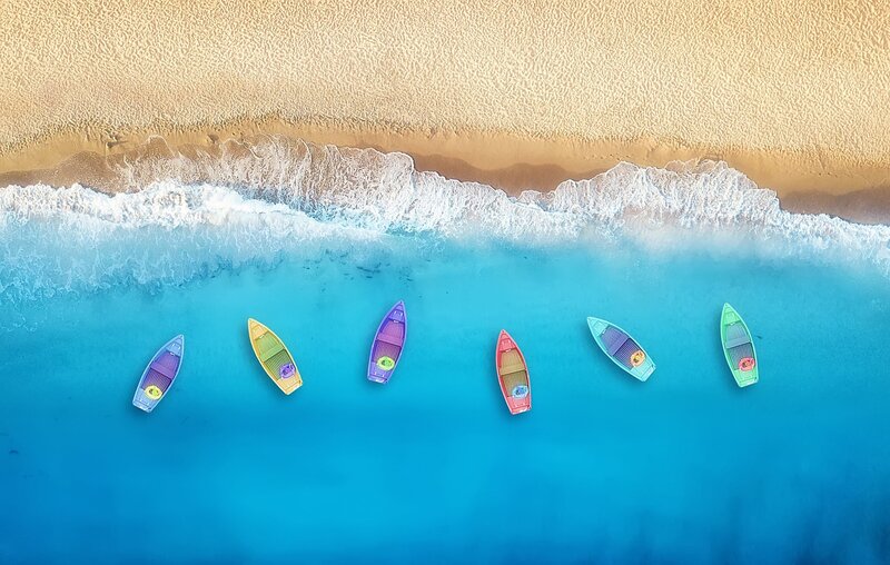 Overhead Photo of Small boats floating close together on the ocean near the shoreline