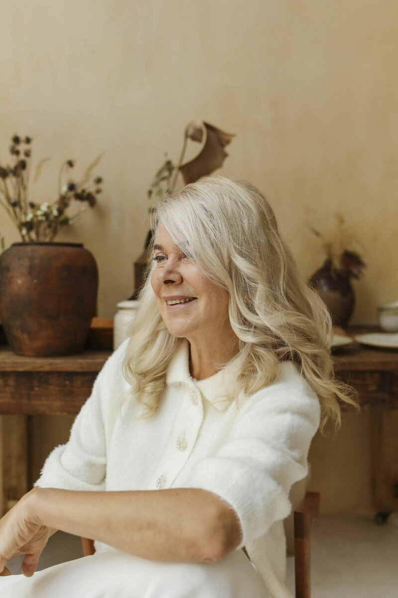 Woman sitting in earthy room smiling
