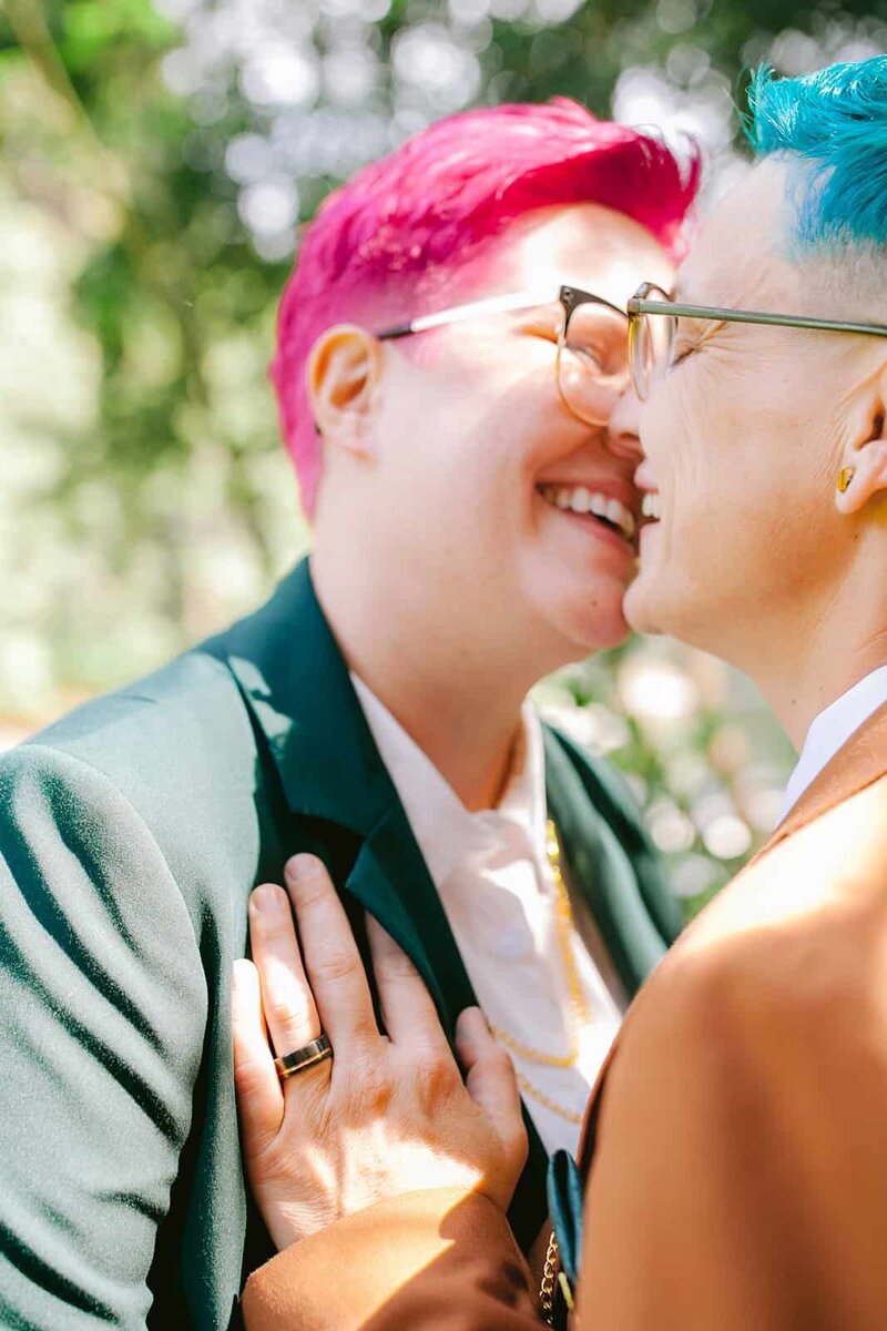 Lesbian brides both kissing and smiling on their wedding day 