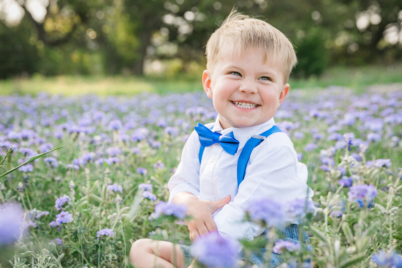 Boy with blue bowtie sitting in bluebonnets, Austin Family Photographer