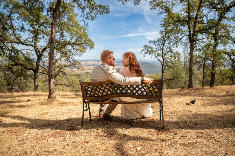 bride and groom sitting on a bench