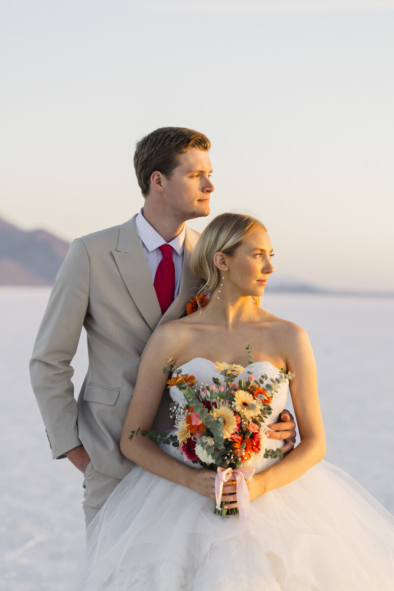 bride and groom standing together while looking into the distance