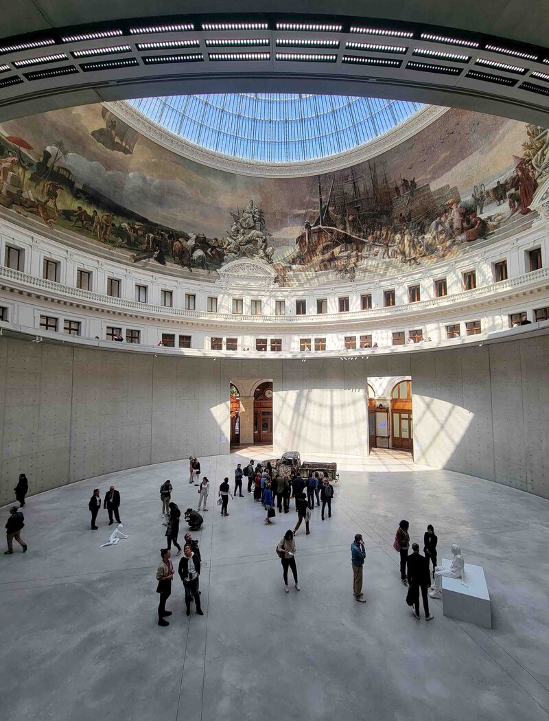 Visitors exploring the grand rotunda of the Bourse de Commerce in Paris, beneath a domed glass ceiling and a panoramic historical mural ©Stephanie Dosch | theViatrix France Private Luxury Travel