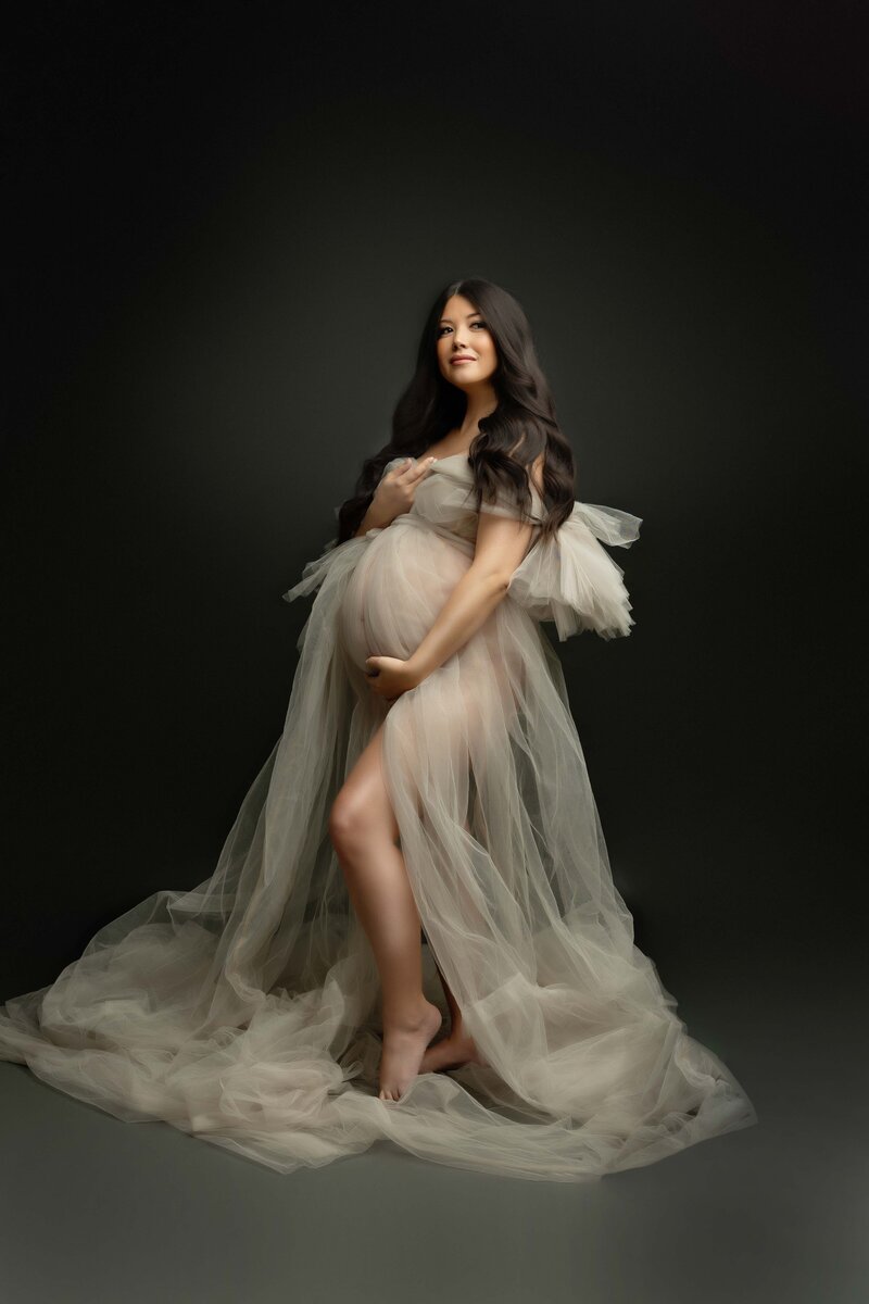 Dark Moody Lit portrait of woman in maternity shoot