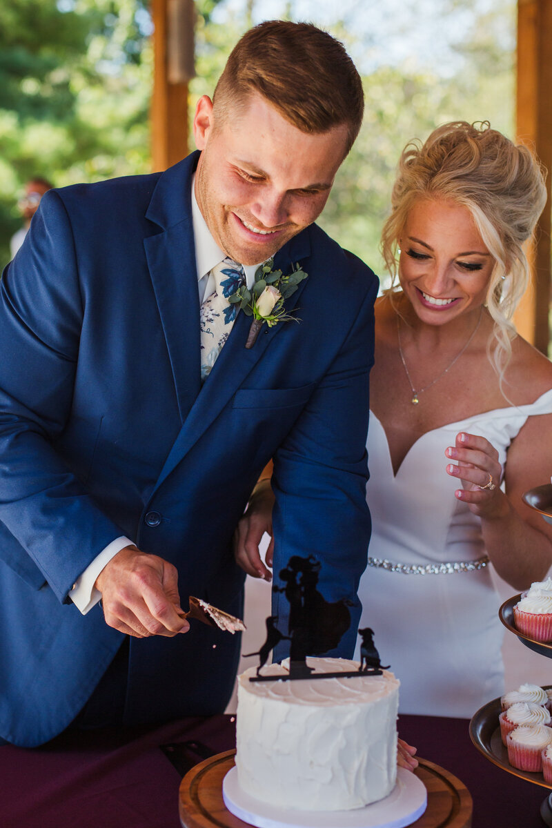 bride and groom cutting cake as husband and wife