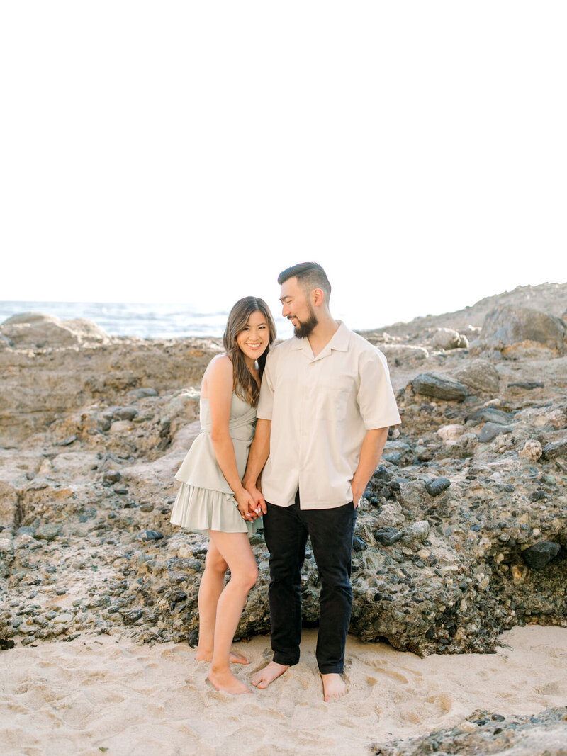 engagement photo of couple at treasure island beach standing in the sand and looking at each other